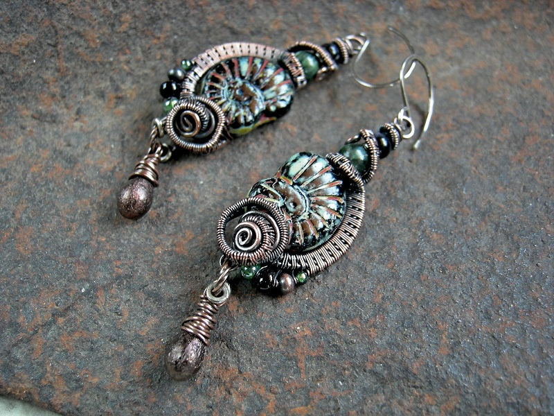 Black glass nautilus bead earrings with oxidized copper wire wrap, glass tear drops & green and black gemstone beads.