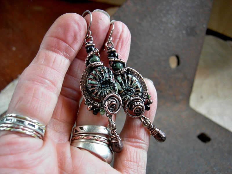 Black glass nautilus bead earrings with oxidized copper wire wrap, glass tear drops & green and black gemstone beads.