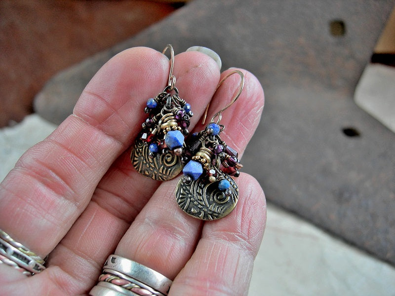 Cluster style earrings with antiqued gold charms, faceted lapis & garnet, violet African glass seed beads & 14kt gold filled earwires.