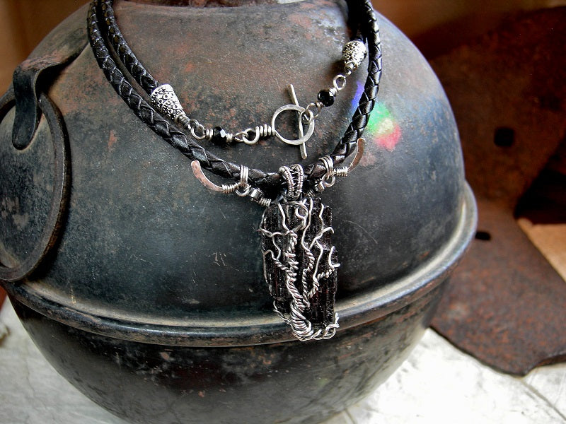 Cord style unisex necklace with black tourmaline crystal & sterling wire wrapped tree. Black leather bolo cord & sterling toggle clasp.