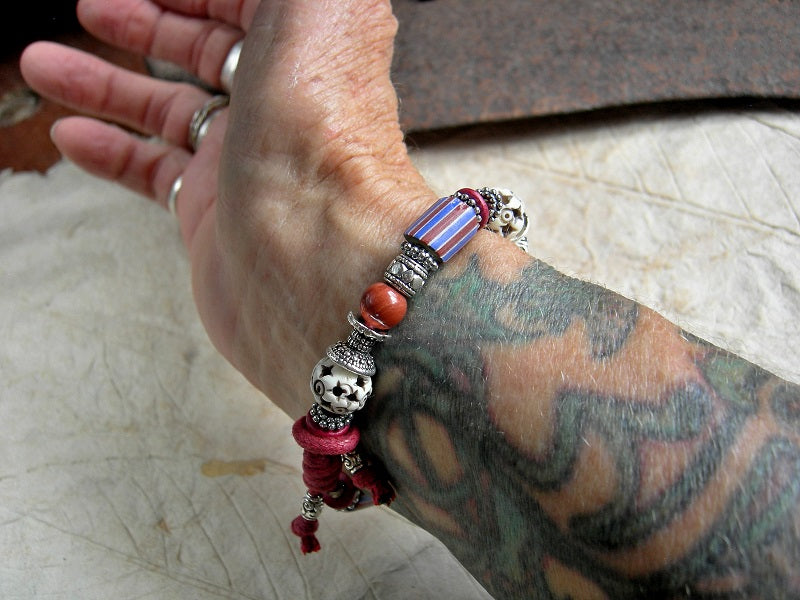 Stripes & Stars, sliding knot bracelet with Venetian glass, red jasper, carved bone & silver details. Red cotton cord.