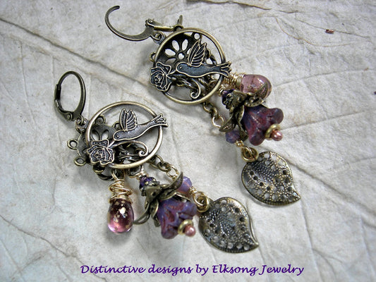 Hummingbirds in Lilacs chandelier earrings with antiqued brass charms, purple glass flowers & teardrops, Swarovski crystals. 
