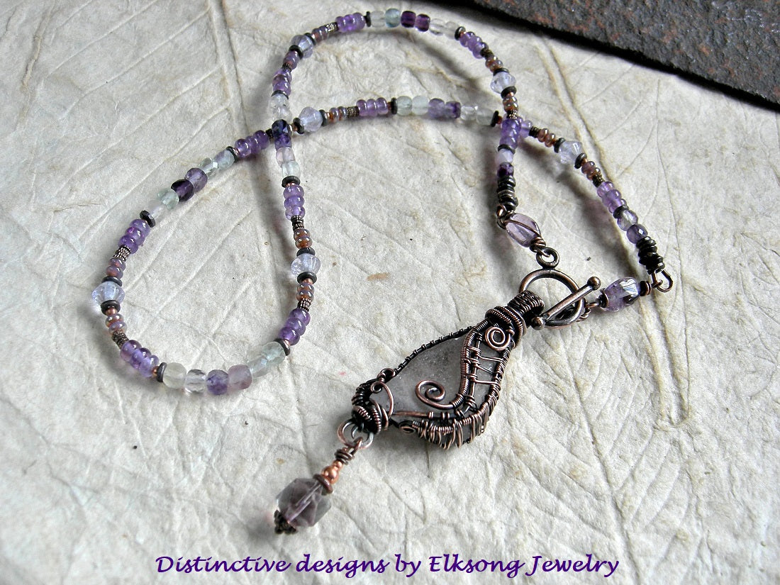 Sea glass wing strung bead necklace with oxidized copper wire wrap, amethyst, green & purple fluorite & copper beads.