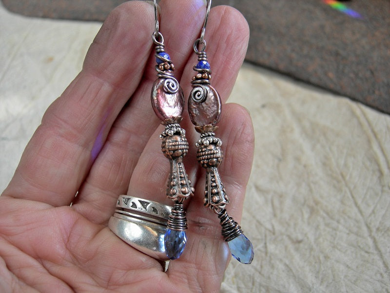 Long drop earrings with faceted lapis, copper iridescent freshwater pearl ovals, faceted blue crystal teardrops, copper & silver Bali style caps.