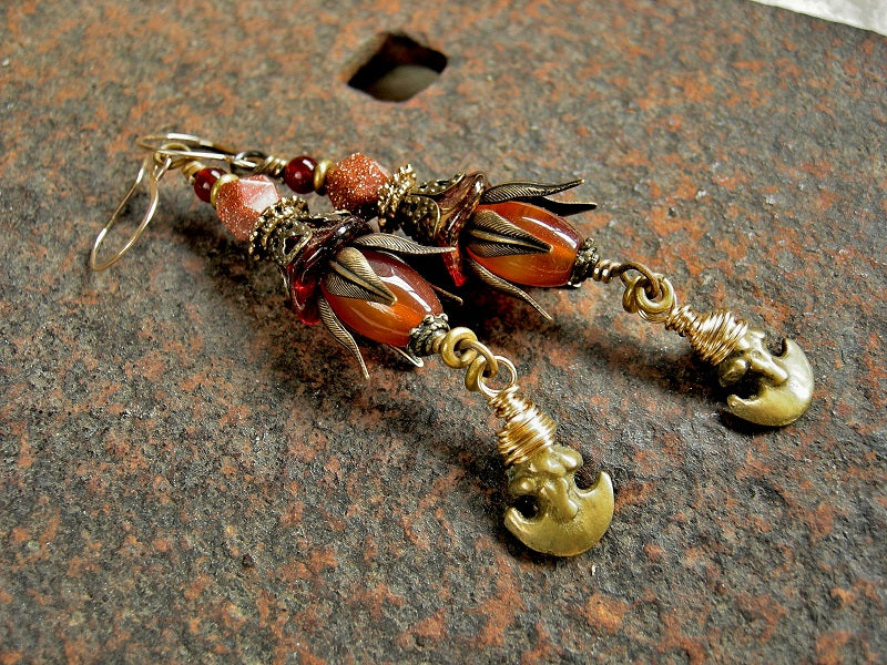 Boho luxe earrings with carnelian, goldstone, glass flowers, antiqued brass caps & vintage ethnic brass crescent charms. 14kt gold filled ear wires.