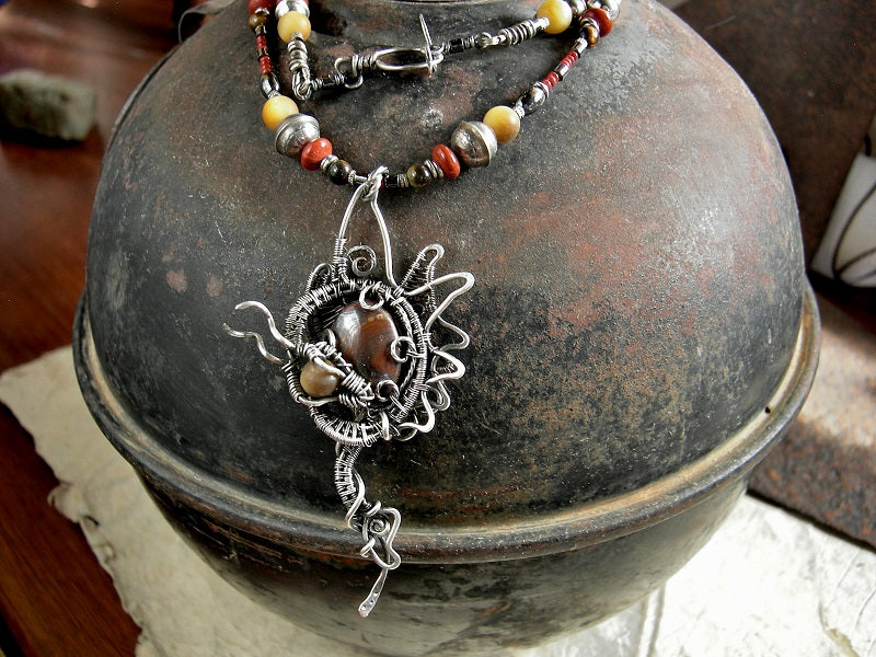 Silver dragon art necklace with sterling wire wrap dragon & tiger iron cabochon focal. Strung red & gold gemstone, sterling bench beads.