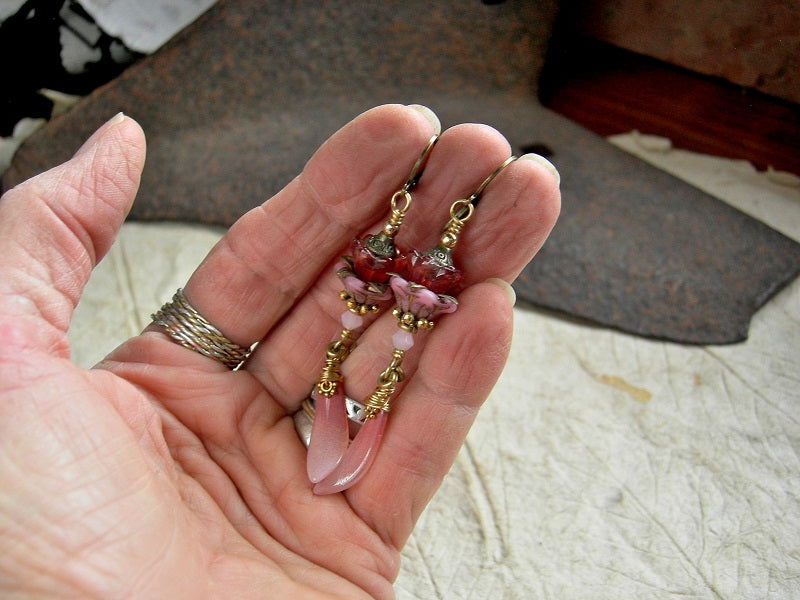 Long drop earrings with pink glass flowers & petal drops, crystal, gold & brass details. Brass lever back ear wires.