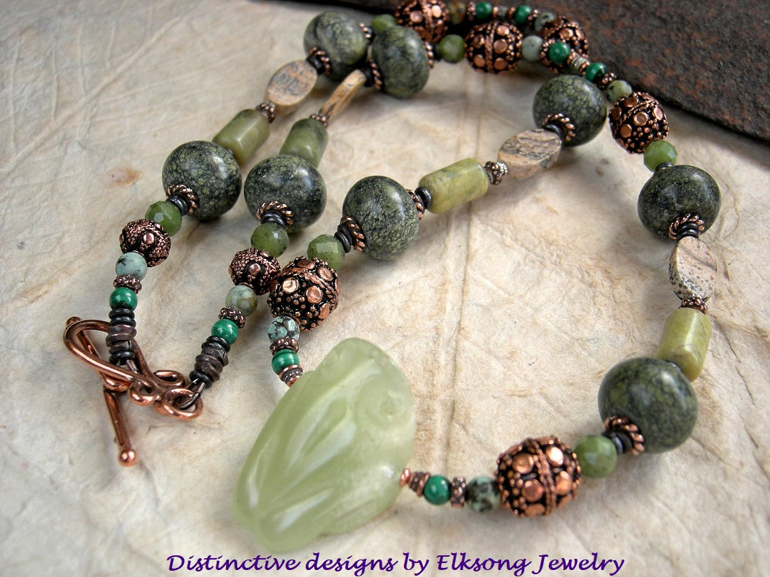 Tree frog necklace, strung bead style with hand carved pale green serpentine frog focal, serpentine, jade, malachite, jasper & copper beads. Copper toggle clasp.