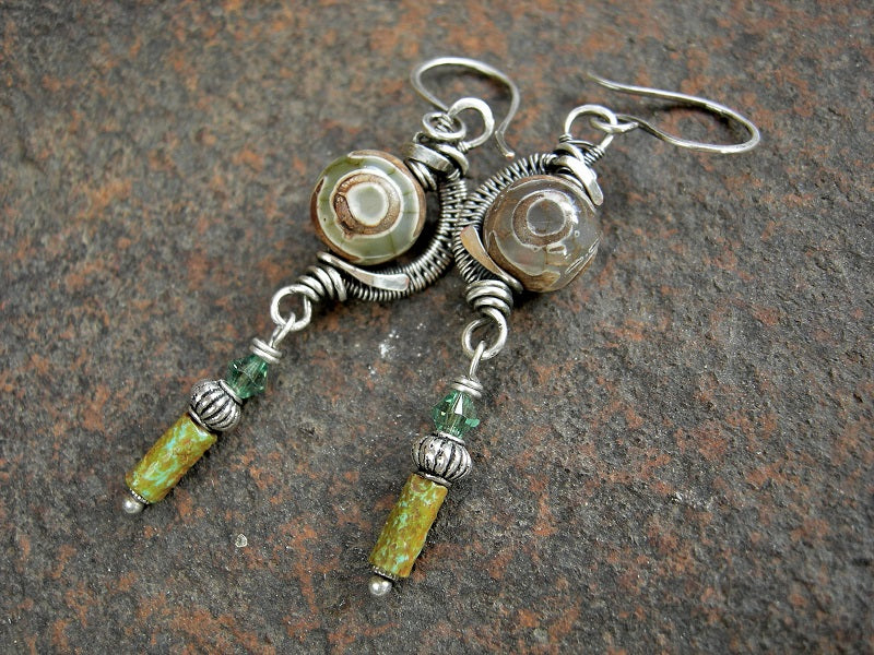 Subtle colored agate rounds in sterling wire wrap curves with green/brown glass cylinders, silver beads & green Swarovski crystals.