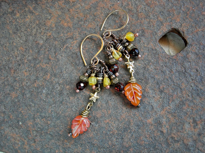 Cluster style earrings with golden & dark cognac amber beads, leaf shaped carved carnelian beads, golden stars & 14kt gold filled ear wires.