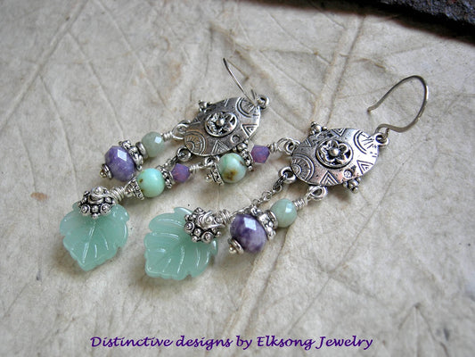 Silver chandelier earrings with green and purple gemstone beads & green glass leaves, branded 'Elksong Jewelry'.