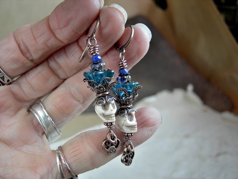 Mellow ivory color sugar skull earrings with teal glass flowers. Natural magnesite beads, antiqued copper details.