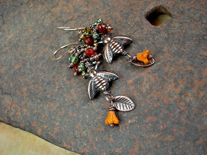 Boho luxe cluster style earrings in orange & green  with oxidized copper bee beads, faceted carnelian, glass flowers & copper leaf charms. 