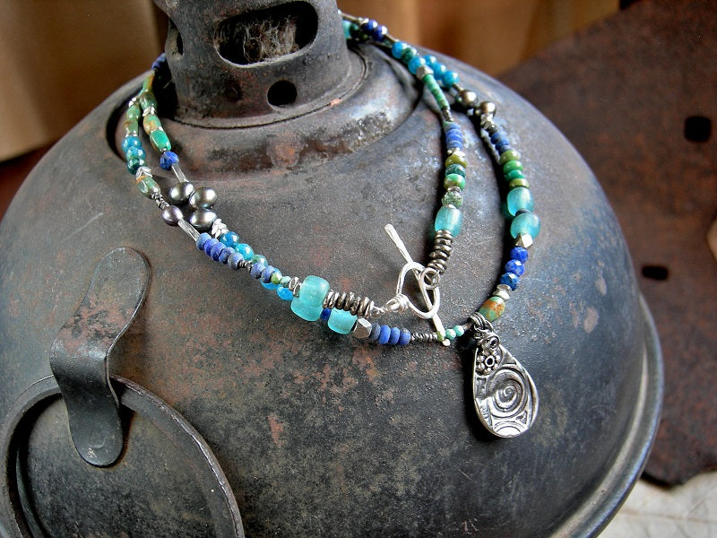 Asymmetrical necklace or wrap bracelet in shades of blue  with lapis, turquoise, apatite, colored pearl & Java glass. Silver details & tear drop focal. 