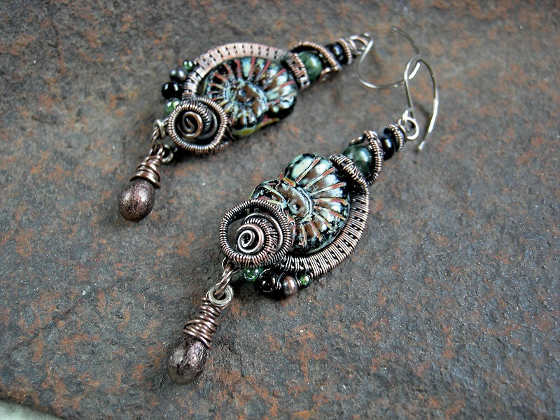 Black glass nautilus bead earrings with oxidized copper wire wrap, glass tear drops & green and black gemstone beads. 