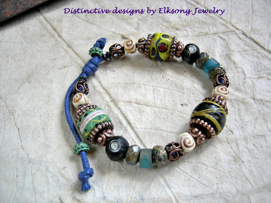 Chunky, colorful unisex slider bracelet with antiqued Venetian glass trade beads, carved bone, faceted glass & various copper beads. 