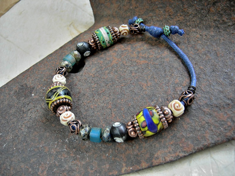 Bohemian unisex adjustable slider bracelet with antiqued Venetian glass trade beads, carved bone, faceted glass & various copper beads. 