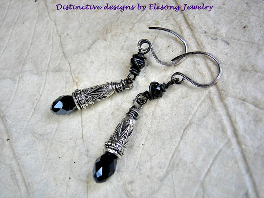 Black & silver drop earrings with faceted tourmaline cubes, ornate silver cone caps & silvery black crystal teardrops. 