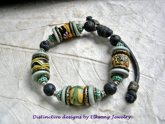 Tribal Rhythm adjustable slider unisex bracelet with chunky black & gold antique Venetian glass trade beads, Greek ceramic, black lava stone & brass. 
