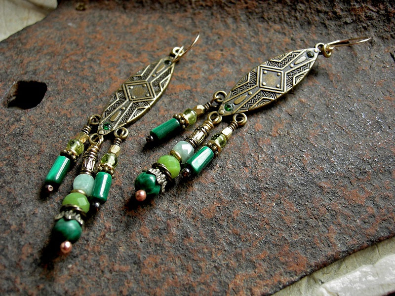 Boho luxe chandelier earrings with elongated brass shield shapes, green gemstone and brass & golden beads & caps. 