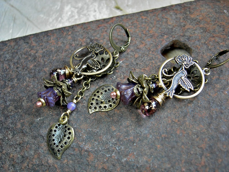 Hummingbirds in Lilacs chandelier earrings with antiqued brass charms, purple glass flowers & teardrops, Swarovski crystals. 