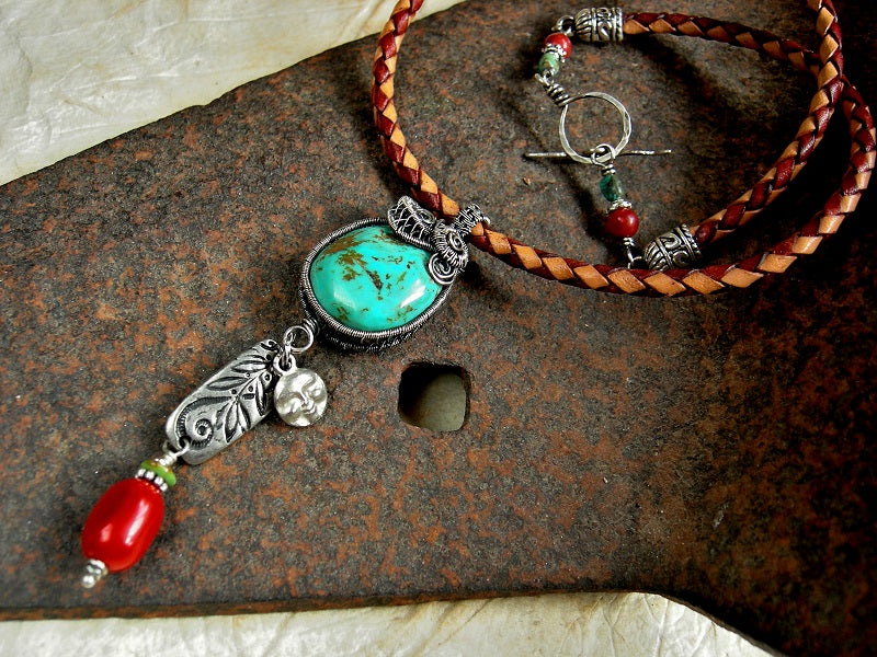 Natural turquoise & sterling wire wrap necklace, on braided leather bolor cord, with coral beads & silver charms. 