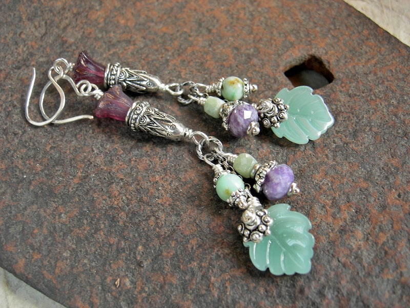 Boho luxe earrings with purple & green gemstone & glass flower & leaf beads, antiqued silver caps & chain. 