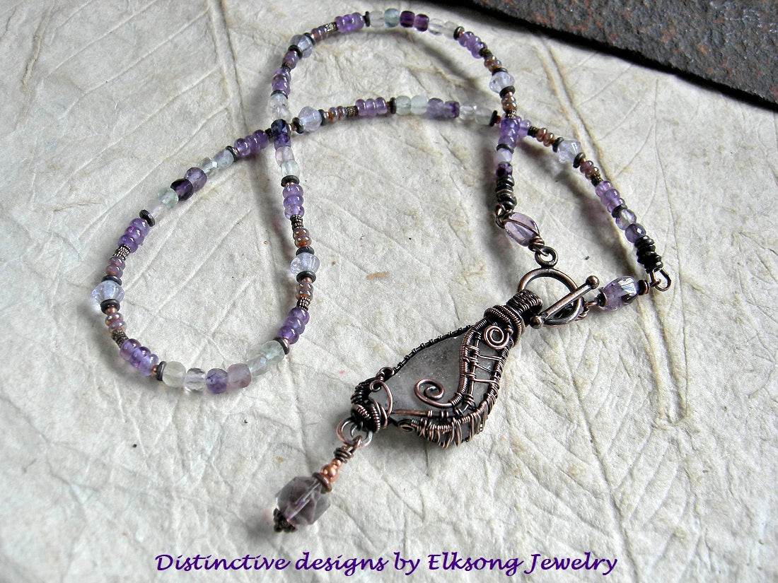 Sea glass wing strung bead necklace with oxidized copper wire wrap, amethyst, green & purple fluorite & copper beads. 