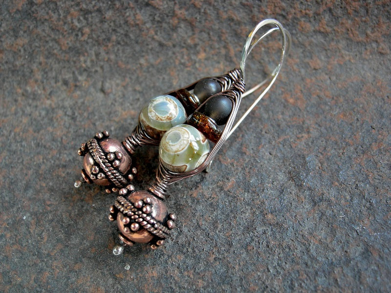 Darkly elegant wrapped hook earrings with ornate copper beads, etched agate, amber slices & matte smoky quartz. Sterling ear wires. 