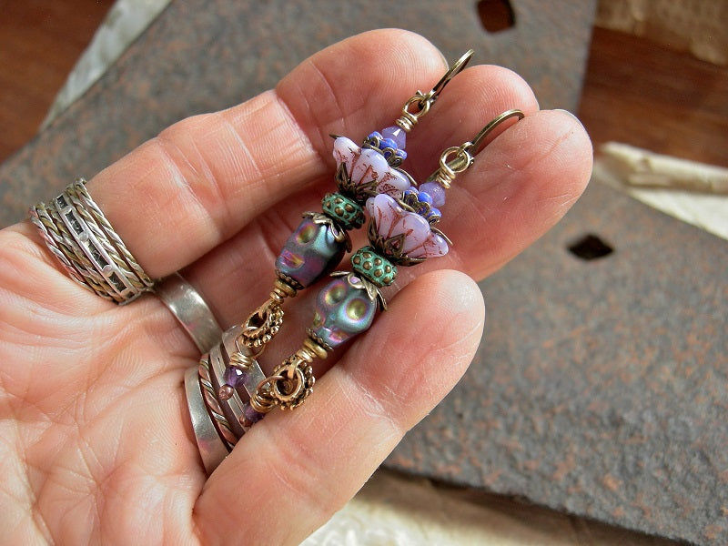 Boho style sugar skull earrings, with lilac & blue glass flowers, amethyst & iridescent hematite skull beads. 