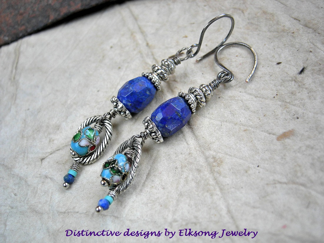 Blue beaded earrings with silver accents on a textured surface, featuring Elksong Jewelry branding.