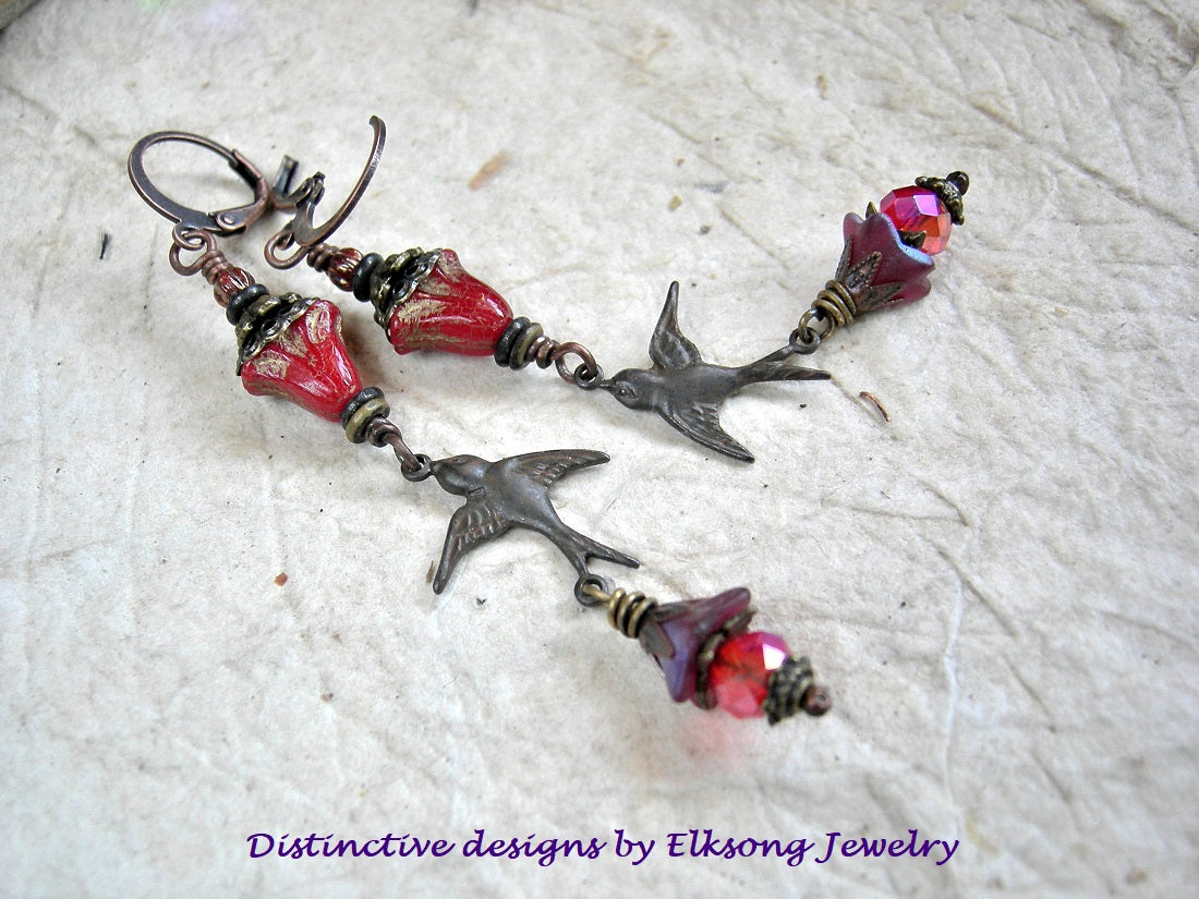 Scarlet glass flower & antiqued bronze bird charm earrings with antiqued brass & copper caps, faceted red crystal rondelles & lever back ear wires. 