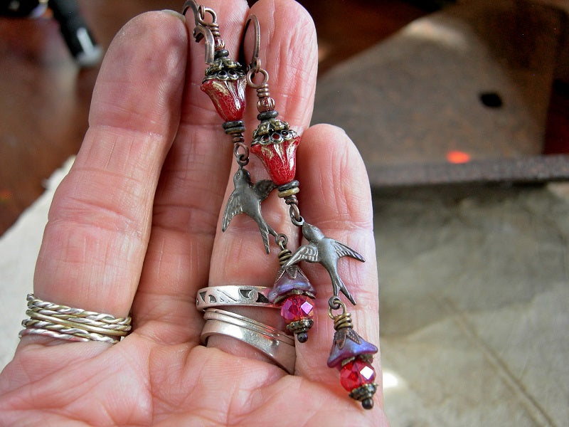 Boho elegant red glass flower & antiqued bronze bird charm earrings with antiqued brass & copper caps, faceted red crystal rondelles & lever back ear wires. 