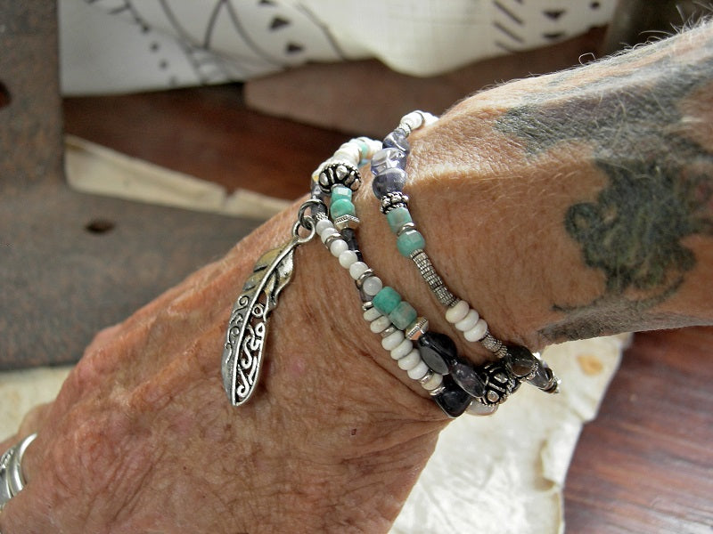 Triple wrap bracelet/necklace with blue & white gemstone beads, mother of pearl, sterling-over-copper beads, feather charm & sterling toggle clasp. 