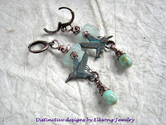Jade Flower earrings with translucent pale green glass flowers, mint green glass tear drops & verdigris hummingbird charms. Lever back ear wires.
