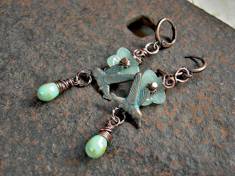 Dainty boho earrings with translucent pale green glass flowers, mint green glass tear drops & verdigris hummingbird charms. Lever back ear wires.