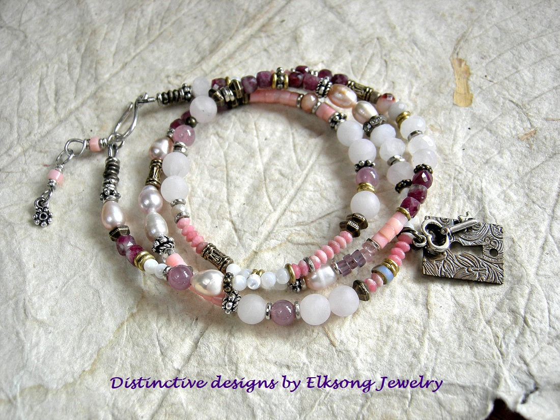 Key To Love wrap bracelet/necklace with rose quartz, pink coral, mother-of-pearl, freshwater pearl, red tourmaline & thulite gemstone beads, mixed silver & antiqued brass beads & focal. Adjustable sterling hook & eye clasp. 
