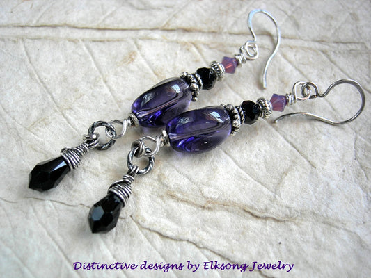 Purple, black & silver beaded earrings on a textured surface with 'Distinctive designs by Elksong Jewelry' text.