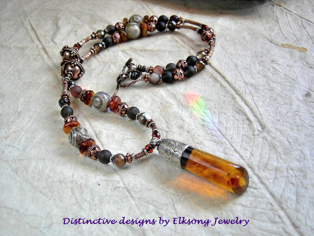 Strung gemstone & copper bead necklace with amber pendant on a textured surface, featuring 'Distinctive designs by Elksong Jewelry'.