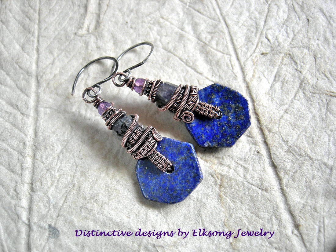 Blue stone earrings with copper wire wrapping on a textured white background, featuring 'Distinctive designs by Elksong Jewelry'.