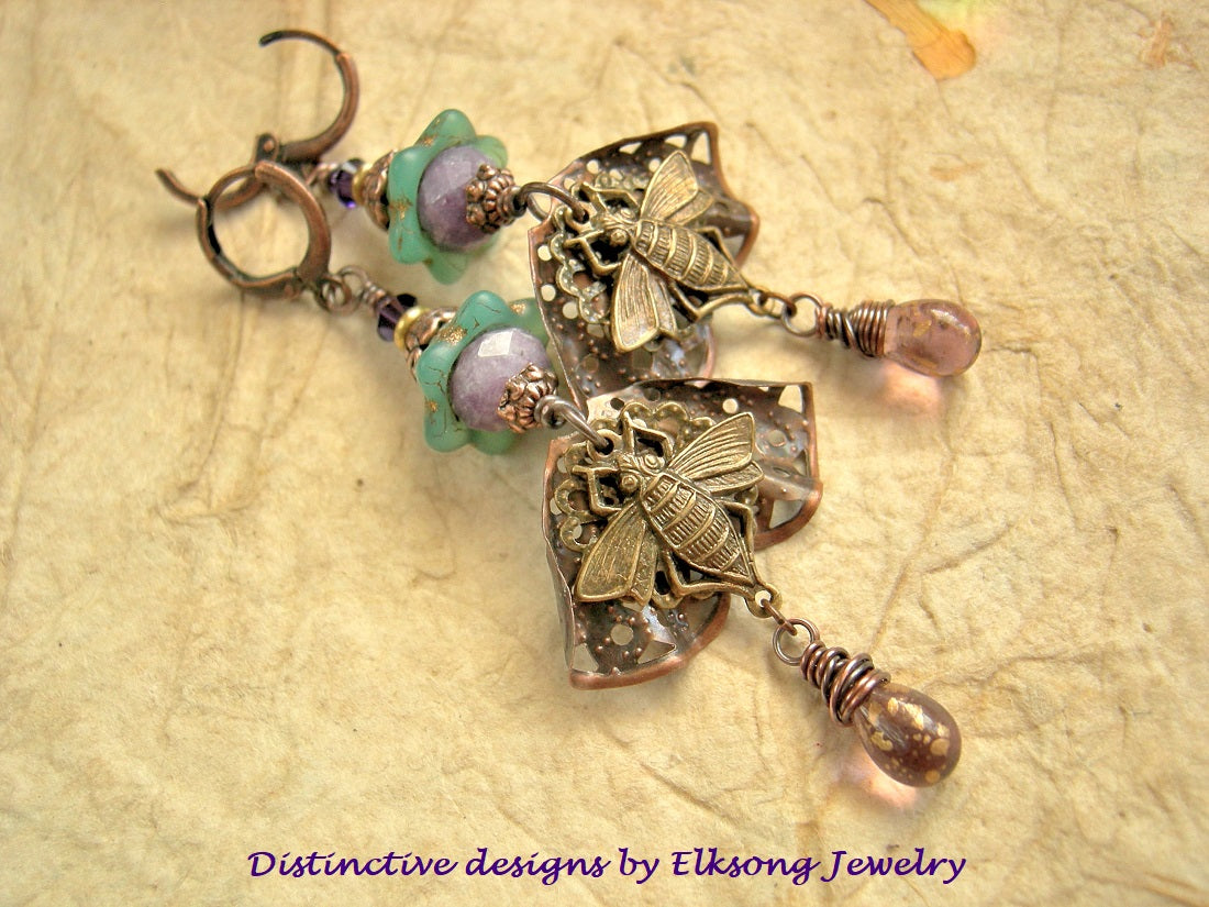 Ornate purple & green earrings with butterfly designs featuring Elksong Jewelry branding.