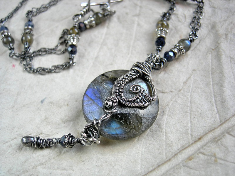 Sterling wire wrap necklace with smoky blue gemstone & oxidized silver. Dark & luminous, boho luxe style.