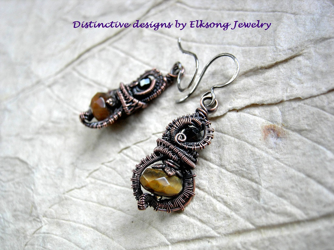 Lush, autumn color earrings with faceted tiger eye & black tourmaline and oxidized copper wire wrap. 