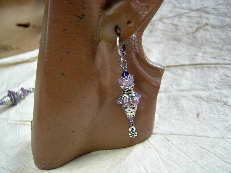 Purple& silver sugar skull earrings with glass flowers, silver finish skull beads & flower drops and Swarovski crystal. 