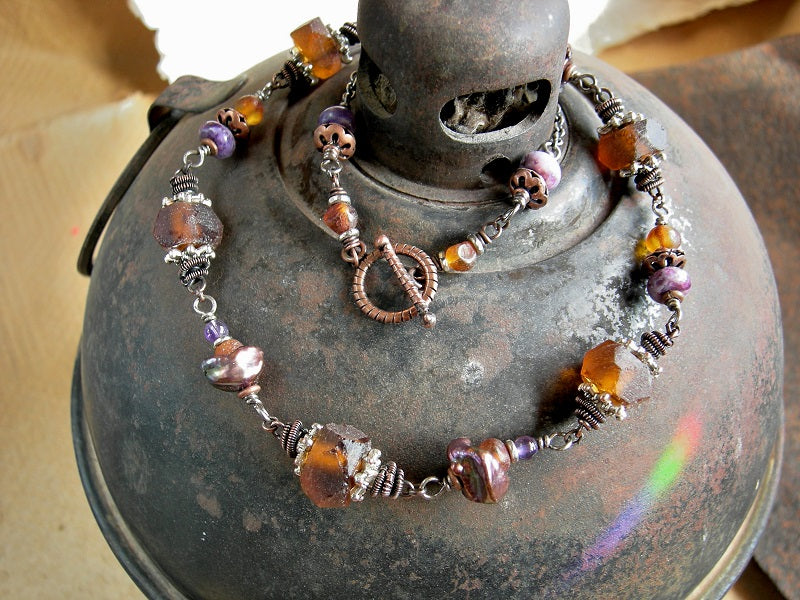 Earthy elegant necklace with natural amber, purple gemstone, recycled glass & keshi pearls. Oxidized copper wire wrap links. 
