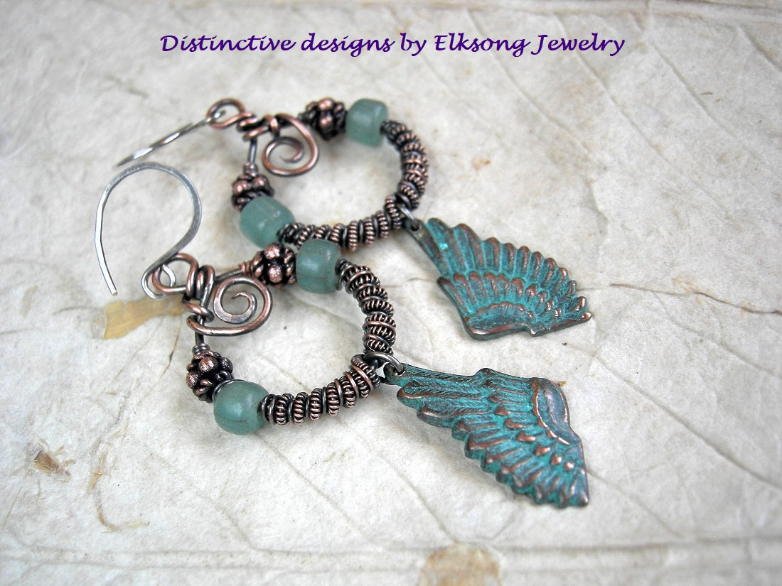 Copper wire wrap earrings, coiled hoops with aqua Java glass & copper beads, verdigris copper wing charms. 