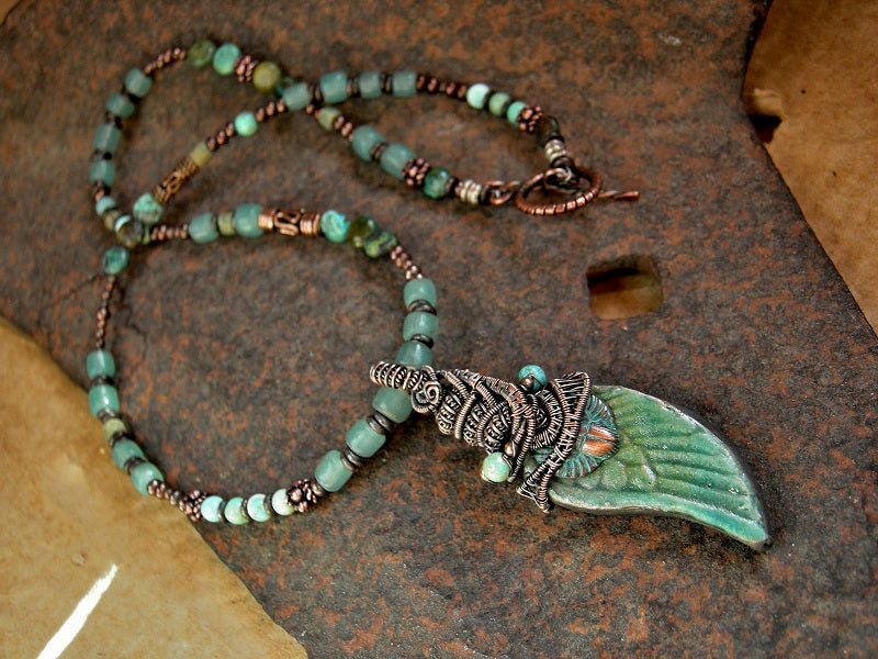 Isis necklace with raku ceramic wing, copper wire wrap & asymmetrical turquoise, vintage Java glass & copper strung beads. 