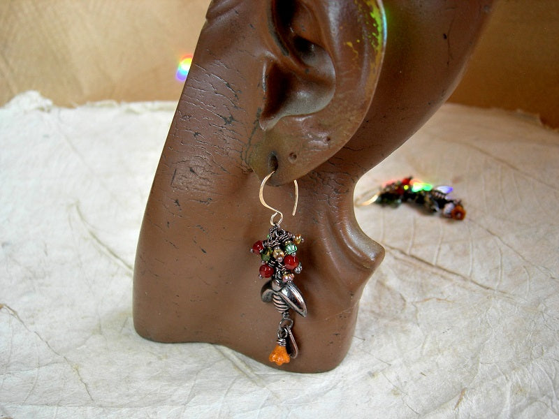 Orange & green cluster style earrings with oxidized copper bee beads, faceted carnelian, glass flowers & copper leaf charms. 