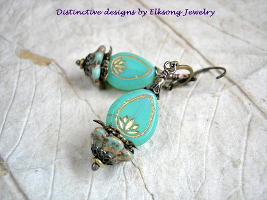 Luminous lotus earrings with opalescent aqua glass drops, glass cup flowers & antiqued brass details. 