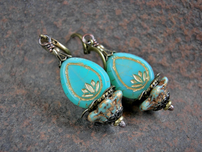 Luminous lotus earrings with opalescent aqua glass drops, glass cup flowers & antiqued brass details. 